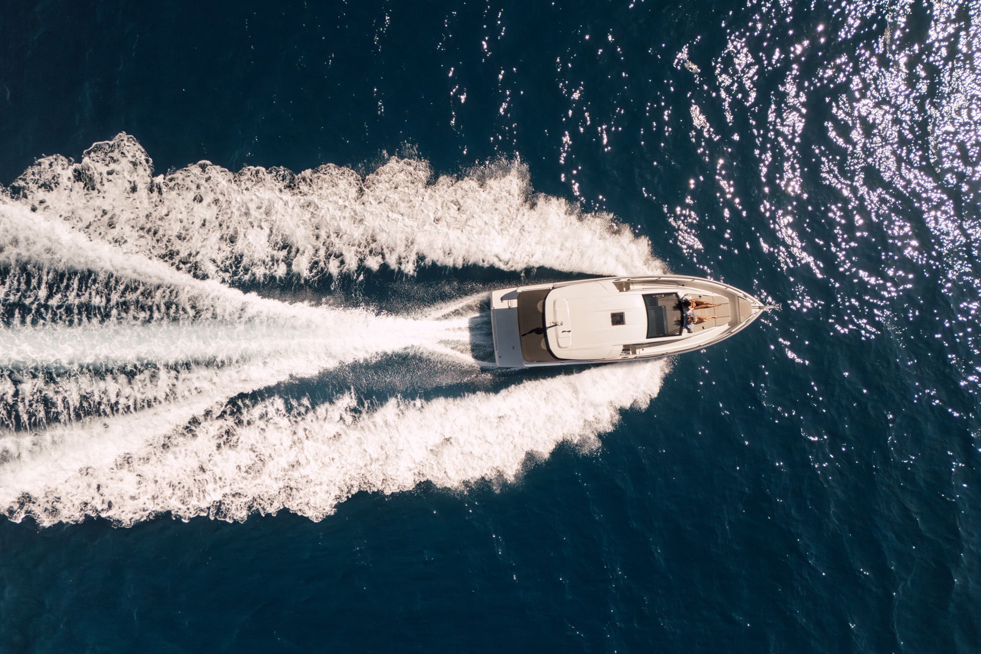 Yacht mit weißem Kielwasser von oben
