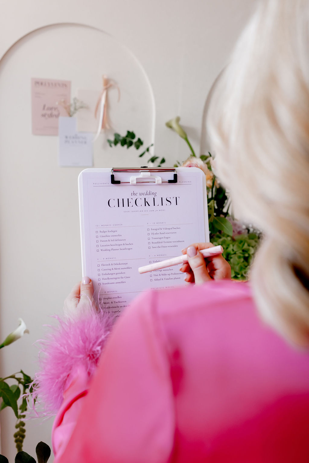 Polly von Pollyvents mit der Wedding Checklist vor dem Moodboard